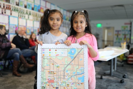 Photo of two girls holding a map for display